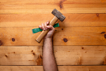 hand grabbing hammer and chisel on light wooden background - Labor Day