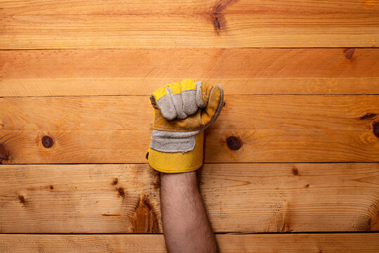 clenched fist wearing leather protective glove light wood background - Labor Day