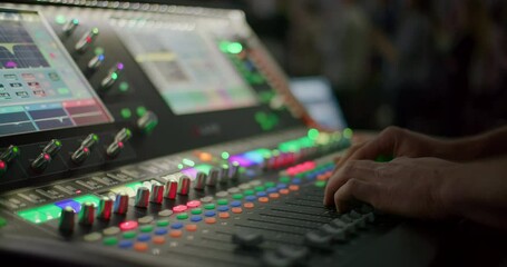 Sound Engineer Hand Controlling Audio on Mixer Console at Live Music Concert. Sound technician professional Works on Mixing Board in Studio or at Night Party. 4K close up handheld shot
