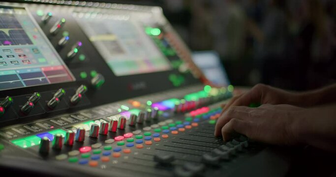 Sound Engineer Hand Controlling Audio on Mixer Console at Live Music Concert. Sound technician professional Works on Mixing Board in Studio or at Night Party. 4K close up handheld shot