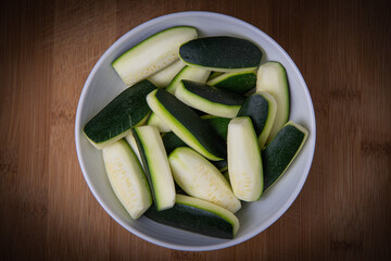 Preparing fresh courgette, zucchini on wood table