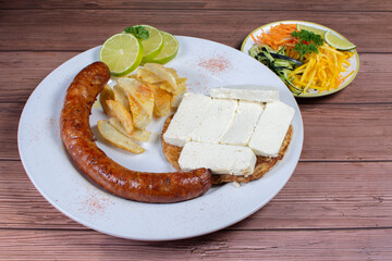 Traditional Colombian food, chorizo, arepa de chocolo with cheese, salad, french fries and salad