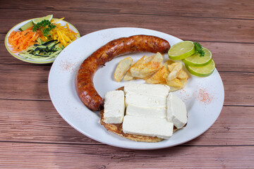 Traditional Colombian food, chorizo, arepa de chocolo with cheese, salad, french fries and salad