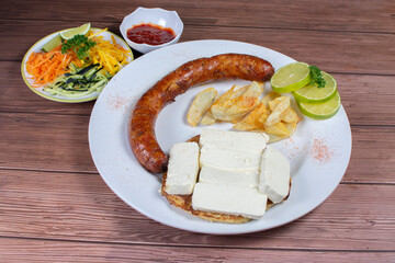 Traditional Colombian food, chorizo, arepa de chocolo with cheese, salad, french fries and salad