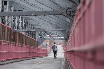 Solo casual man walking the cycling lane on Williamsburg Bridge, Brooklyn, New York City, USA - obrazy, fototapety, plakaty