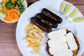 Traditional Colombian food, black pudding, chocolo arepa with cheese, salad, french fries and salad