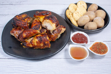 Roast chicken, traditional Colombian food, accompanied by boiled potato, arepa, sauces