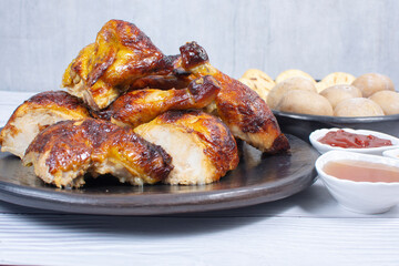 Roast chicken, traditional Colombian food, accompanied by boiled potato, arepa, sauces
