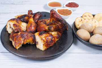 Roast chicken, traditional Colombian food, accompanied by boiled potato, arepa, sauces