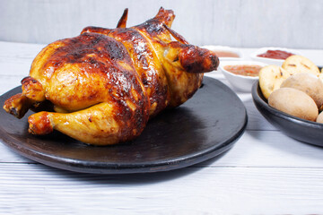Roast chicken, traditional Colombian food, accompanied by boiled potato, arepa, sauces