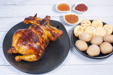 Roast chicken, traditional Colombian food, accompanied by boiled potato, arepa, sauces
