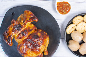 Roast chicken, traditional Colombian food, accompanied by boiled potato, arepa, sauces