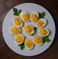 Stuffed eggs with crab crumbs, mayonnaise and parsley macro on a plate