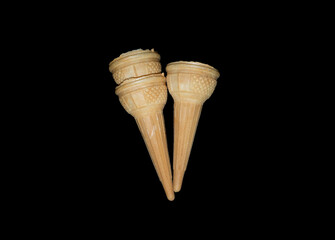 Three empty ice cream cones on dark black background.