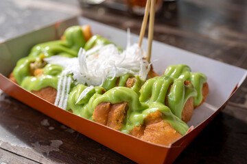 Deep-fried dough sticks topping with green steamed custard.