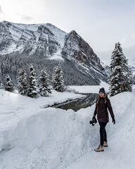 One person standing at Lake Louise in Alberta during winter with tourism, tourist shot vibe. 