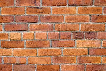 A brick wall with various shades of orange and red.