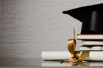 Birrete con libros apilados y diploma al lado. Concepto de graduación.