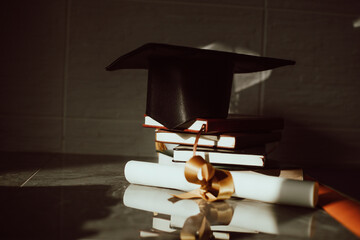 Birrete con libros apilados y diploma al lado. Concepto de graduación. - obrazy, fototapety, plakaty