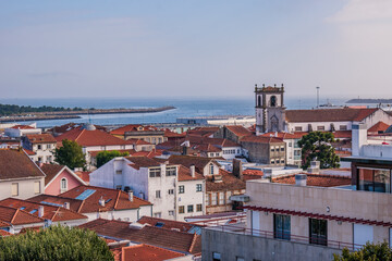 Roofs and urban houses in aerial view with church and convent tower of São Domingos with sea in the background, Viana do Castelo PORTUGAL