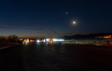 Cars and semi trucks parked at a highway rest area at dawn