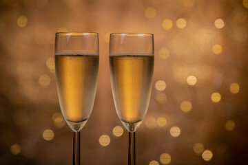 Champagne glasses over holiday bokeh blinking background, glasses with sparkling wine, celebration, party