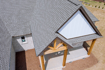 Edge of roof shingles on top of the house asphalt tiles the roof