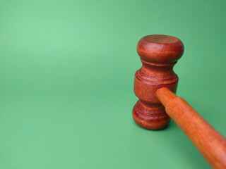 Wooden gavel on a green background with copy space.