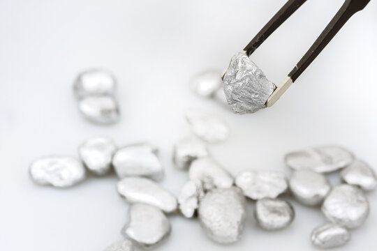 Geologist crawls the ore to determine the type of mineral and rock or pure platinum or silver or rare minerals from the mine on a white background.