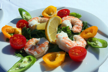 Shrimps and vegetables on the dinner plate.