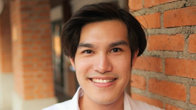 Happy Young Asian Man Smiling on Camera. High Quality 4K Slomotion Footage Portrait of Office worker or Student. Thailand.