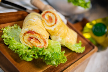 Tomato-rolled egg omelette recipe on a bed of salad - obrazy, fototapety, plakaty