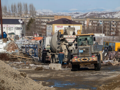 kazakhstan, Ust-Kamenogorsk, february 15, 2021: Construction site. Truck and wheel loader. People, workers. New residentential area