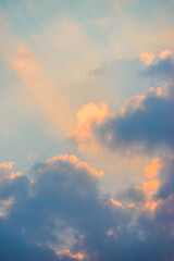 Blue and orange sunset sky with rays of sun. Sun rays slipping through clouds while sun sets.