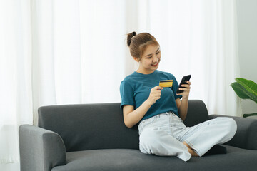 Beautiful young Asia woman working with smart phone in living room