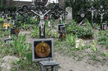 Fototapeta na wymiar graves with golden bitcoin declining crypto market and donations during the war