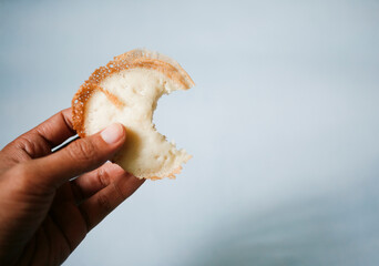 hand holding traditional snack called apem from java Indonesia, made from rice flour, sugar and coconut milk.