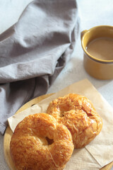 A croissant served with coffee is placed on a white table.