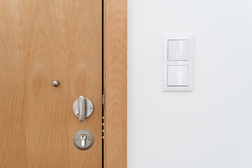 Wooden door and light switch on the wall