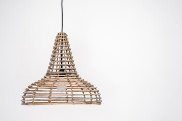 Stylish wicker lamp hanging from ceiling in room