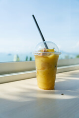 Mango yogurt smoothie set up on wooden plate