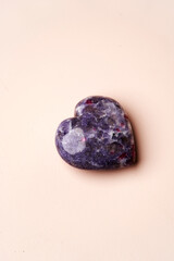 Heart shaped crystal stone on pink background