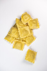 Tasty raw ravioli with flour and spinach on white background, process of making italian ravioli