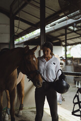 Woman groomer washes a horse's hooves after class at the hippodrome. A woman takes care of a horse,...