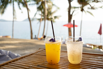 Orange juice on table seaside during sunset sky.