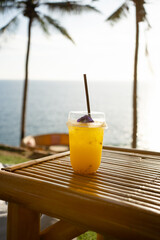 Orange juice on table seaside during sunset sky. 