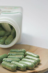 Andrographis paniculata capsules on a wooden spoon.