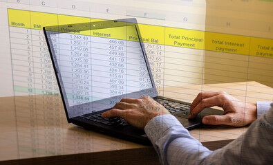 Close up shot of a man working on computer with blended image of a loan amortization table. Banking