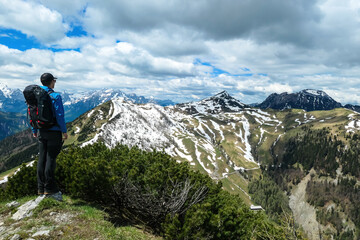 Hiker man breathing on the summit of Hahnkogel (Klek) with scenic view on mountain peaks in the Karawanks and Julian Alps, Carinthia, Austria. Border with Slovenia. Triglav National Park. Freedom