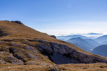 A panoramic view on the mountain peaks of the Hochschwab Region in Upper Styria, Austria. Cloudless weather on a sunny summer day in the Alps. Blue misty valley and soft hills. Concept freedom
